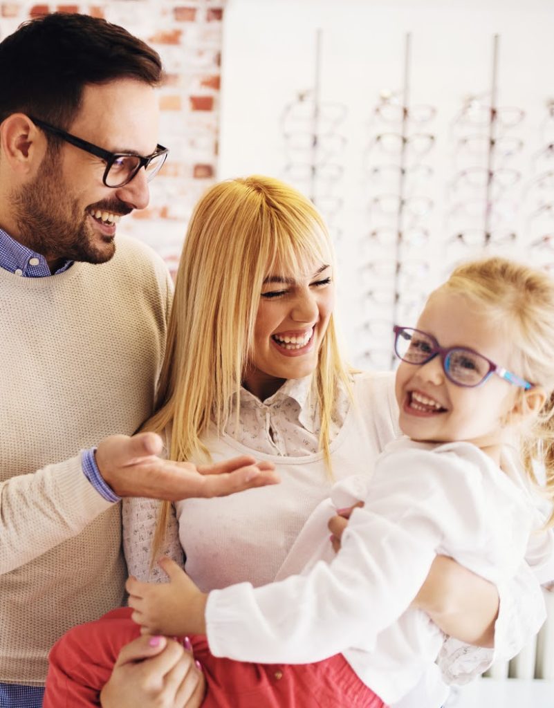 Family at optometrist office helping daughter choose a pair of glasses