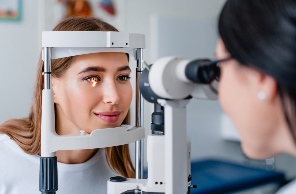 Young women undergoing eye exam by her optometrist