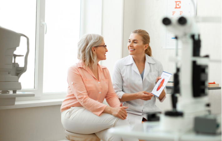 Optometrist talking to patient about her options regarding glasses and contact lenses.