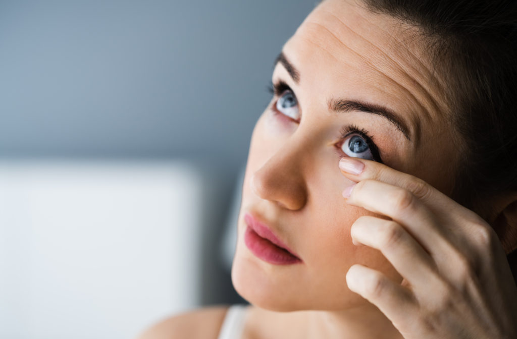 Women experiencing dry eye and touching her eye