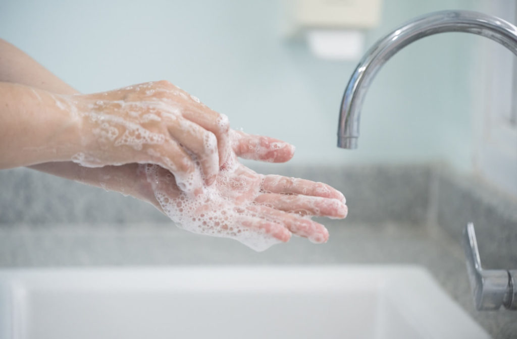 A pair of sudsy hands practicing good hygiene.