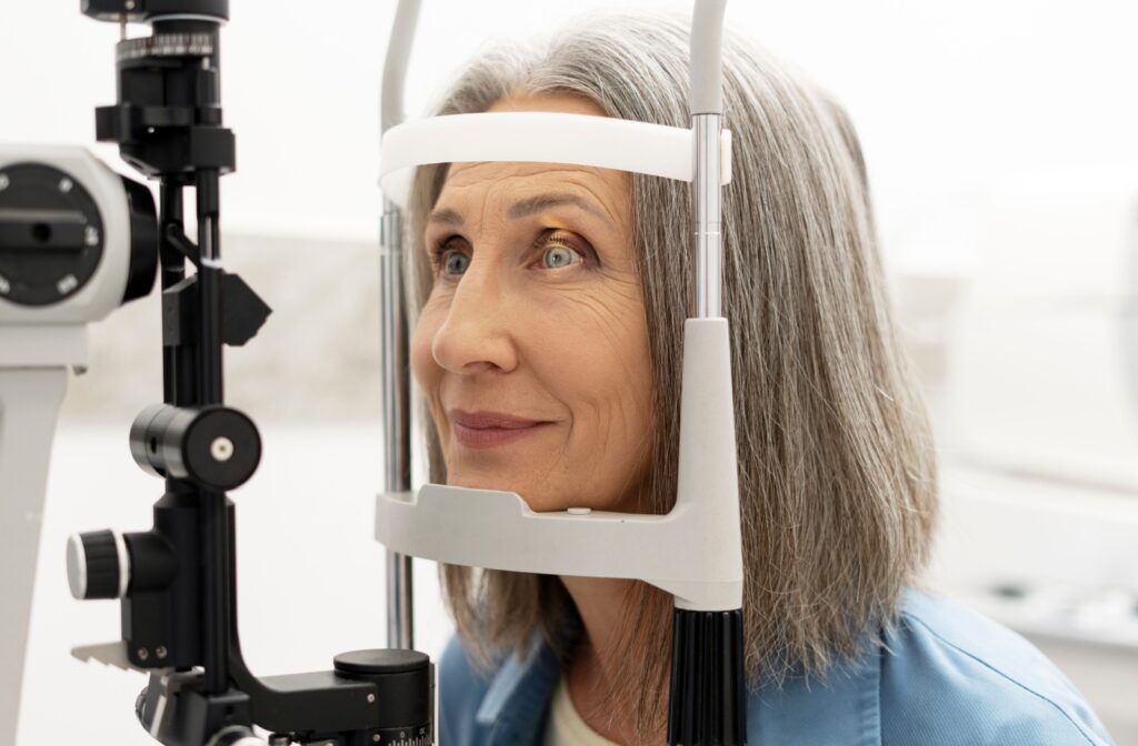 Woman undergoing an eye exam with her head positioned in diagnostic equipment to check for floaters