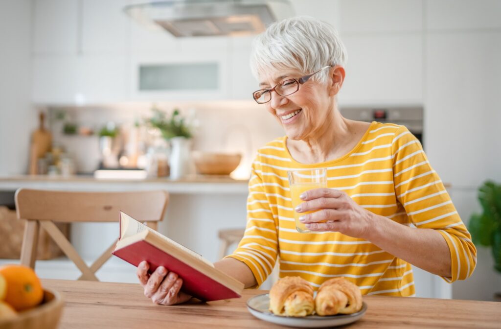 An older adult enjoys reading without trouble thanks to their eyeglasses.