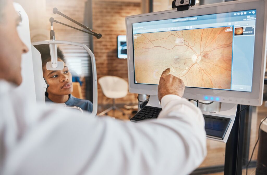 An eye doctor pointing to a screen that shows a digital scan of a retina