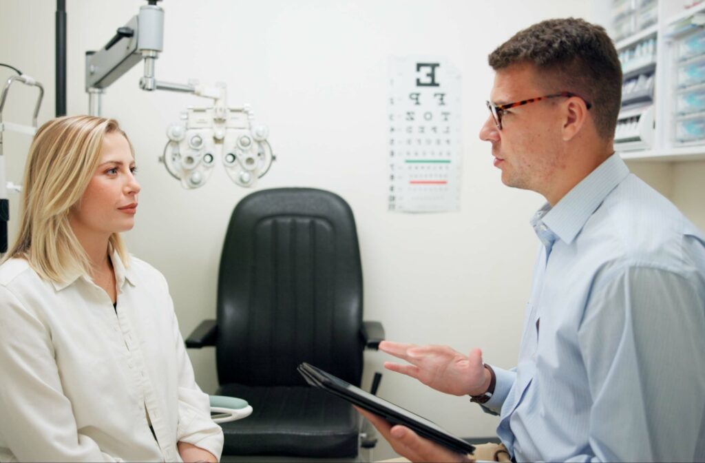 A woman sitting in an optometrists office speaking to an eye doctor