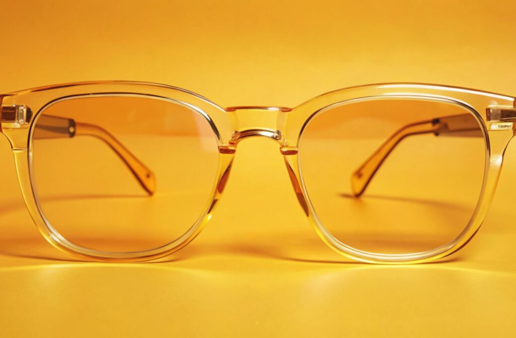 A pair of yellow transparent glasses in front of a yellow background